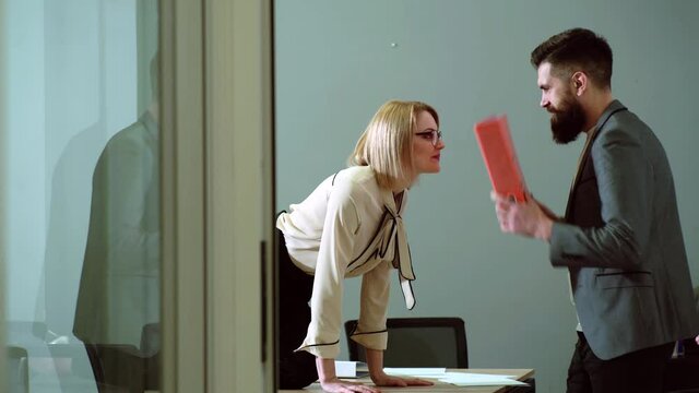 Work romance. Sexy female office worker flirting in workplace. Secretary and boss. Sexual harassment and office abuse concept. Young boss seduces female employee. Abuse of work status.