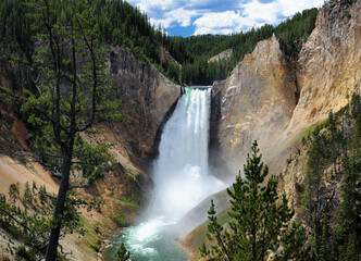 View To The Lower Yellowstone Falls From Red Rock Point On A Sunny Summer Day With A Clear Blue Sky And A Few Clouds