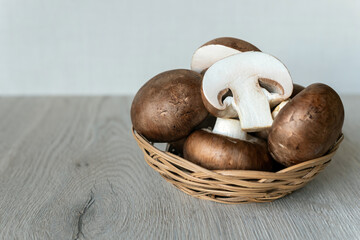 Brown royal mushrooms in a wicker plate, background.