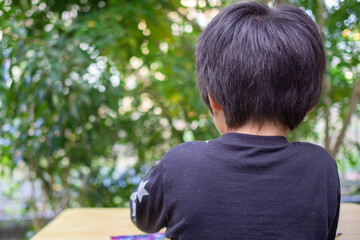 シマトネリコの木のある庭で遊ぶ日本人の子供