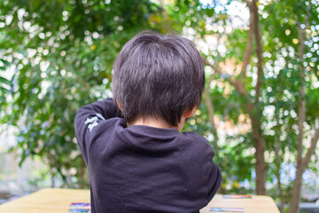 シマトネリコの木のある庭で遊ぶ日本人の子供