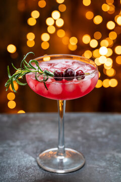 Christmas cranberry cocktail with lights in the background