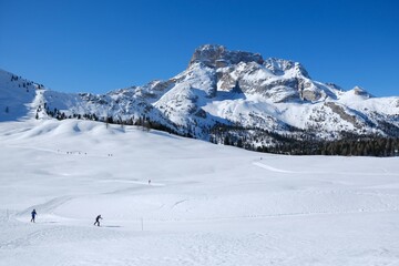 Beautiful winter mountain landscape with cross-country ski tracks and silhouette of running skiers. Piazza Prato plateau, Sexten Dolomites, South Tyrol, Italy
