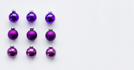 Purple Christmas baubles decoration on bright background. Flat lay. Holiday concept.