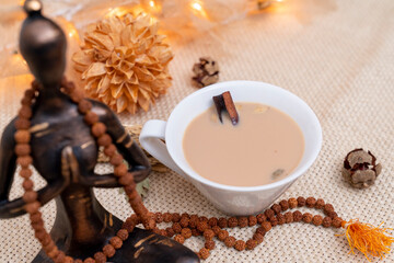 Yogi cinnamon tea on meditation decoration background. Alternative medicine with herbal tea. Healthy and relaxing life concept. Winter tea.