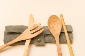 Set of Eco friendly bamboo cutlery on camel color background. Plastic free concept. Close-up, top view.