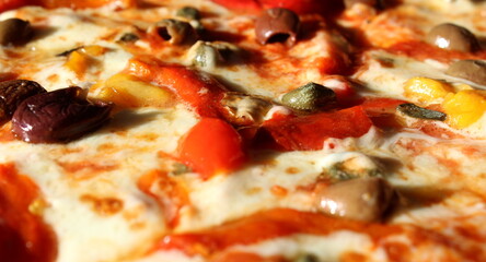 Pizza con formaggio, pomodori, peperoni, capperi e olive