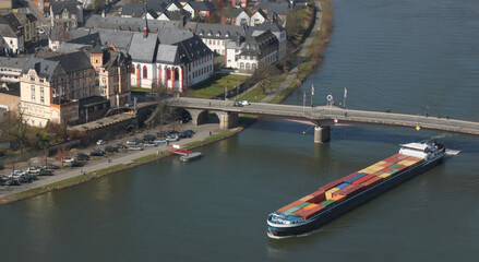 Inland cargo ship with colorful container freight passing a bridge in the historic old town of...