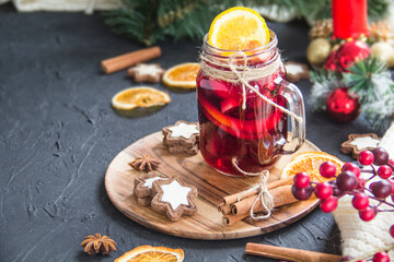 Christmas hot mulled wine with cinnamon cardamom and anise. Dark vintage dirty background. Creative atmospheric decoration