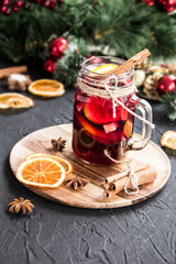 Christmas hot mulled wine with cinnamon cardamom and anise. Dark vintage dirty background. Creative atmospheric decoration