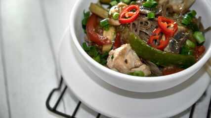  Soba noodles with chicken, hot pepper, zucchini, mushrooms, green onions on the  wooden background. Selective focus. Asian food