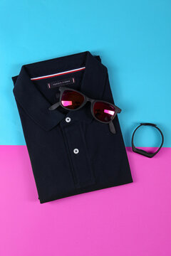 Jeddah Saudi Arabia  November 11 2020 tommy hilfiger Creative party decoration concept. Black Sunglasses  polo shirt props for parties on color background top view flat lay copy space. Father's day, M