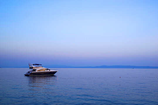 Image of a luxurious yacht on the ocean. Sunset colours.