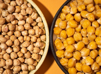 Texture Chickpeas in small yellow and brown ceramic plate bowl isolated on orange background.vegetarian dish. style minimalism.