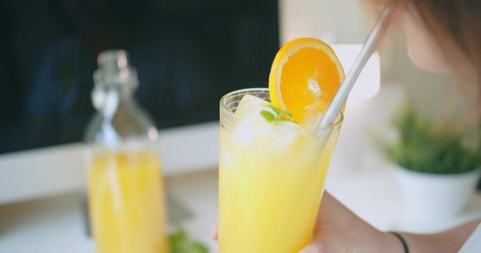 young woman drinking Juicy fresh orange juice with straw, healthy lifestyle refreshment summer concept