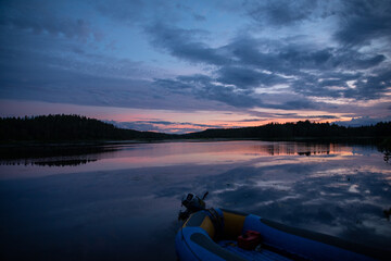 Evening sunset on the river. Boats stand near the shore.