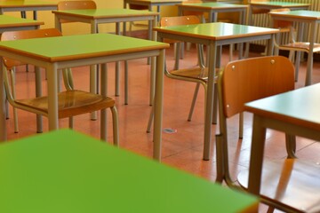 Closed schools and empty desks in Europe and around the world due to the coronavirus emergency. On the floor you can see the spacing stamps.
