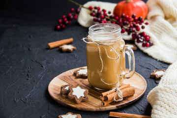 Pumpkin spiced latte or coffee in a cup on a turquoise vintage background. Autumn, fall, or winter hot drink. Cozy breakfast or snack.