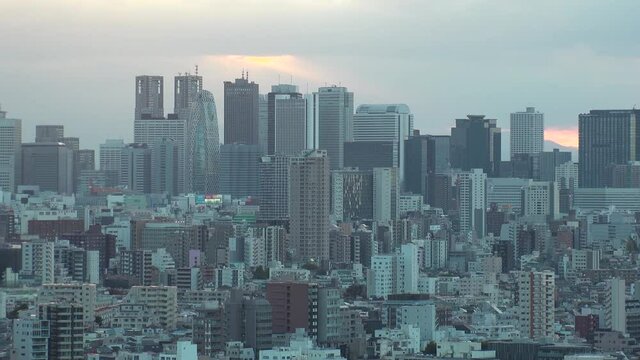 TOKYO, JAPAN : Aerial high angle sunrise CITYSCAPE of TOKYO. View of buildings at around Shinjuku. Japanese urban metropolis concept shot. Long time lapse shot night to morning. Zoom out shot.