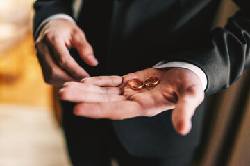 Gold wedding rings on the palm of the groom