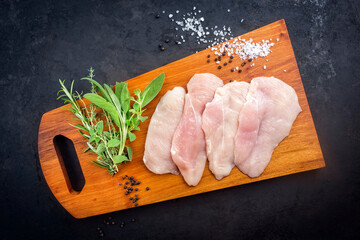Rohes traditionelles Hähnchen Schnitzel mit Tomaten und Kräuter angeboten als Draufsicht auf...