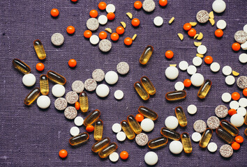 Fototapeta na wymiar Colored different pills Over Violet Background