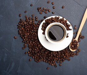 Coffee beans and cup of coffee on blue concrete background