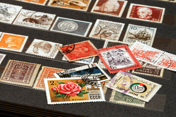 Various old postage stamps from various countries in the philatelic album