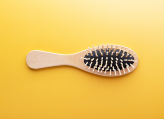Hairstyle concept with hair brush on yellow background.