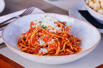 spaghetti bolognese with parmesan cheese and herbs.