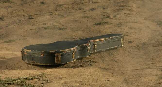 guitar case flies and falls to the ground