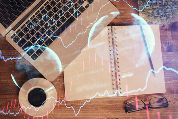 Financial market graph and top view computer on the desktop background. Double exposure. Investment concept.