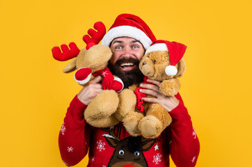 Taking advantages of Christmas sales. new year party. celebrate winter holidays. merry christmas to you. xmas shopping time. reindeer and bear toy. happy bearded mature man in santa claus hat