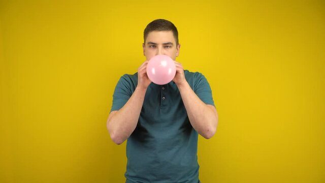 Человек надувает шарик
