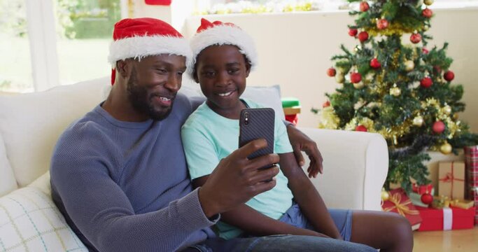 African american father and son having a videocall on smartphone