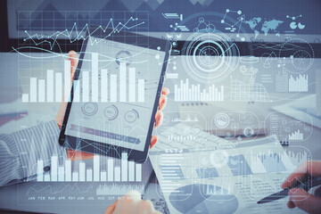 Double exposure of man's hands holding and using a digital device and forex graph drawing. Financial market concept.