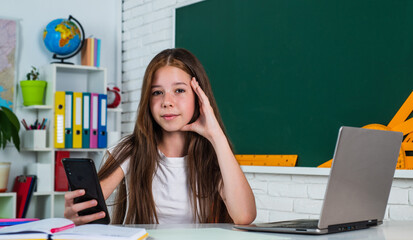 child pupil sit at table and use computer. girl is college student. back to school. teen girl work...