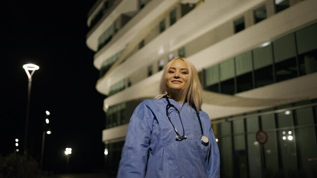 Young female medical intern takes off medical mask during night shift