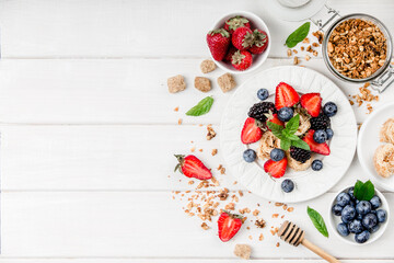 Naklejka na ściany i meble Healthy breakfast with granola, fruits, berries on white background.