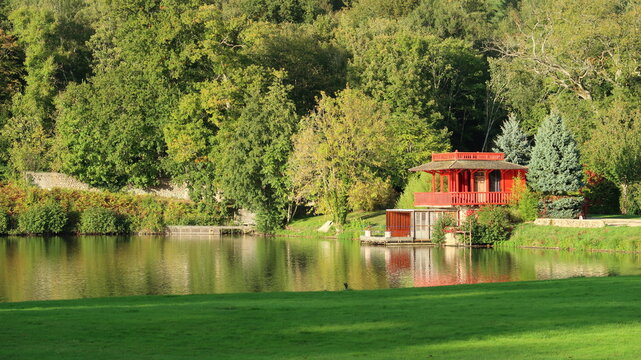 Pavillon rouge au bord du lac de l'abbaye des Vaux de Cernay, bord&eacute; d'arbres, dans la vall&eacute;e de Chevreuse (France)