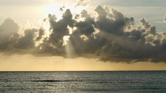 Beautiful natural view of rays of light through the clouds on a sunset in Florida beach overlooking the horizon and the sea. Handheld shot