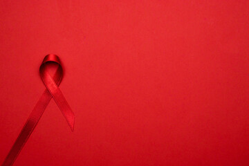 Breast cancer woman. Red ribbon symbol in hiv world day on dark red background. Awareness aids and...