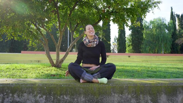 Yoga teacher stretching and laughing looks at a student during class