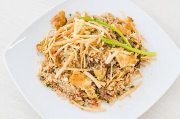 Peruvian food, "arroz chaufa" fried rice with wantan over white background.