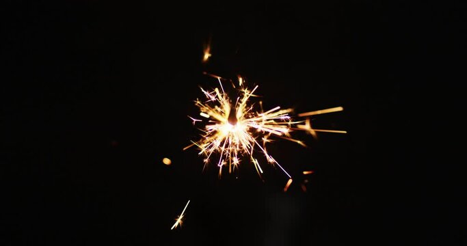 Lit party sparkler sparkling on black background