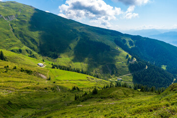 Fototapeta premium Idyllic landscape with mountain top above green pastures under a blue sky with white clouds high up in the Venediger Alps in summer. salzburg region, austria in europe