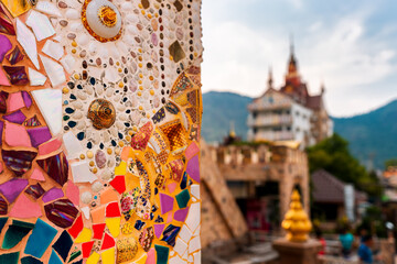 Naklejka premium Art mosaic glass on the wall in Buddhist Thailand temple. Beautiful Landmark and Attraction of Asia. Asian culture and religion