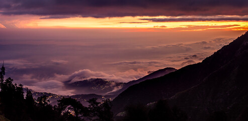 Mesmerizing view of cloudy red sunset sky background during sunset enroute to Triund trekking trail from Mcleodganj, Dhramshala, Himachal Pradesh, India.
