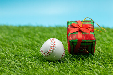 Baseball Holiday with baseball and Christmas decoration on green grass