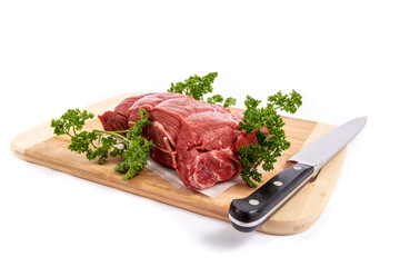 A beef top sirloin roast on a cutting board with garnish of parsley and a cast iron roasting pan on a pure white background
